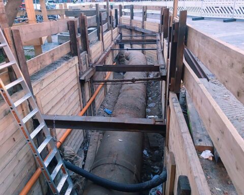 Arbeiter installieren Infrastruktur: Kanalnetz und Technik zur Verbesserung der Sicherheit der kritischen Systeme.