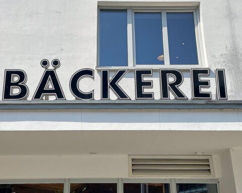 Eine Frau wird in einer Bäckerei von Mitarbeitern nach einem Diebstahl festgehalten.