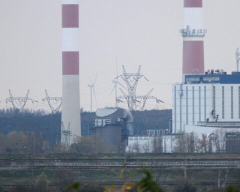 Ein altes Kohlekraftwerk, umgeben von industrialisierten Strukturen, symbolisiert Energiewende und Umweltdiskussion.
