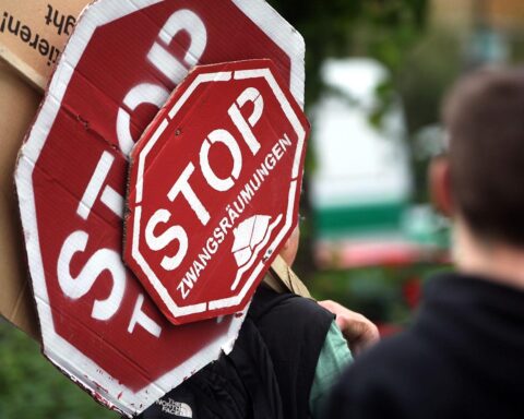 Protestierende Menschen im Schnee, die gegen Zwangsräumungen und für soziale Rechte demonstrieren.
