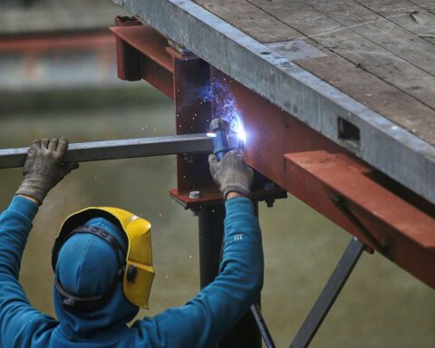Schweißer bei der Arbeit, Symbol für Arbeitsrechte und faire Bedingungen in der Pflege und Baugewerbe.