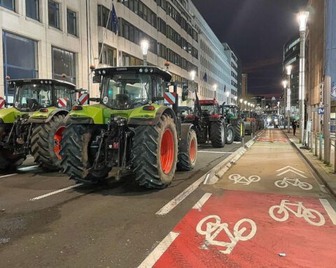 Bauernproteste gegen Mercosur-Abkommen, symbolisiert durch demonstrierende Landwirte mit Plakaten und Fahnen.