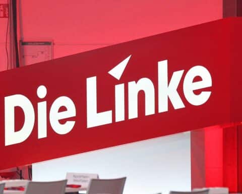Linke-Parteitag mit jungen, engagierten Mitgliedern; Symbol für politischen Einfluss und soziale Veränderungen.