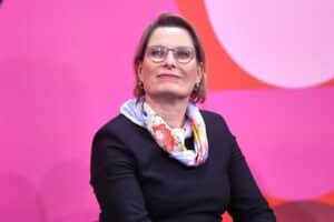 Stefanie Hubig, lächelnd, steht vor dem Bundestag und symbolisiert Mieterrechte und Reformen.