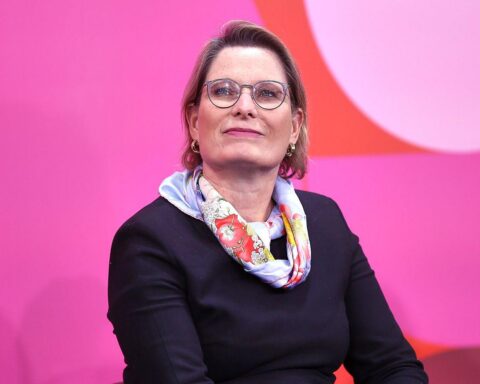 Stefanie Hubig, lächelnd, steht vor dem Bundestag und symbolisiert Mieterrechte und Reformen.