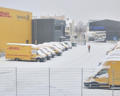 DHL-Zustellbasis mit Lieferwagen, Sicherheitshinweise zur Betrugsprävention und QR-Codes im Fokus.