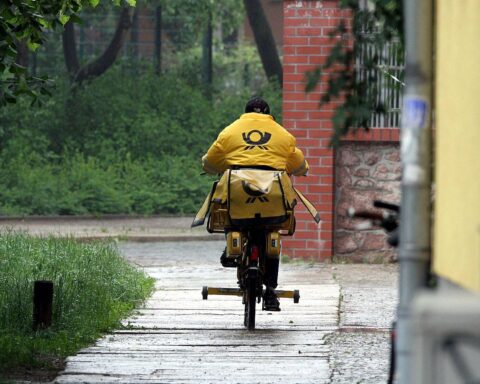 Postbotin liefert Briefe, während DHL-Chef Meyer über Beschwerden und Zustellprobleme spricht.