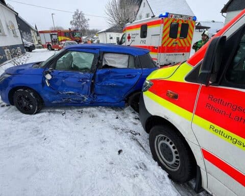 Rettungswagen und Pkw nach Kollision, Einsatzkräfte sichern Unfallstelle, leicht verletzte Personen.
