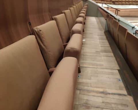 Zuschauerplätze in einem Theater, Symbol für den kulturellen Austausch und die finanzielle Unterstützung.