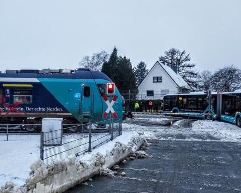 Schulbus auf Gleis, Kinder warnen Zug, dramatische Rettungssituation, keine Verletzten, Polizei ermittelt.