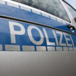 Polizeiauto vor einem Stadtgarten, Symbol für Gewaltverbrechen und Gefahren in Städten.