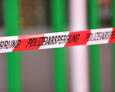 Polizeiabsperrung an Unfallstelle mit schwer beschädigtem Auto und Rettungsdiensten.