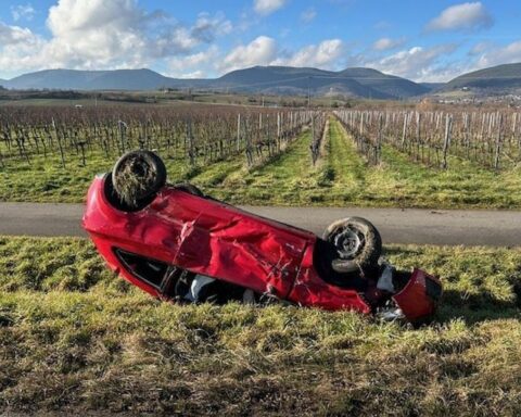 Pkw im Graben nach schwerem Verkehrsunfall, Polizei und Kran im Einsatz.