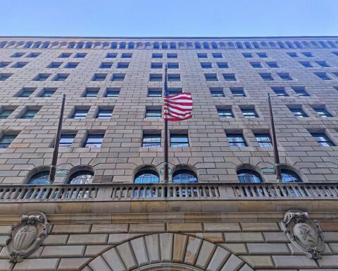 Federal Reserve-Logo mit Zinssatzanzeige und wirtschaftlichen Indikatoren im Hintergrund.