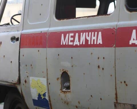 Zerschossener Kleinbus in Kriegsgebiet symbolisiert die andauernden Folgen des Ukraine-Kriegs.