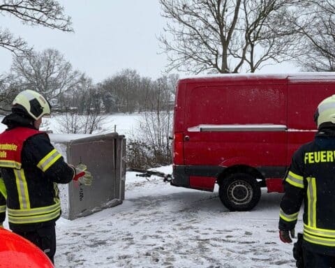 Umgestürzter Anhänger blockiert Straße, Feuerwehr und Rettungsdienst im Einsatz zur Bergung.