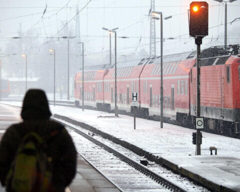 Schneebedeckte Gleise und Züge, symbolisieren Verspätungen und Probleme der Deutschen Bahn im Winter.