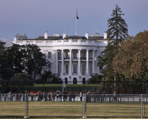 Weißes Haus mit amerikanischer Flagge, symbolisierend US-Sicherheitsstrategie und internationale Beziehungen.