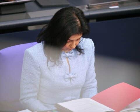 Katherina Reiche in Berlin, umgeben von Dokumenten und Reden, symbolisiert skrupulöses Mikromanagement.