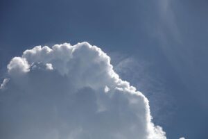 Blauer Himmel mit Schönwetterwolken über Bayern, kontrastrierende Wetterbedingungen erwarten die Menschen.
