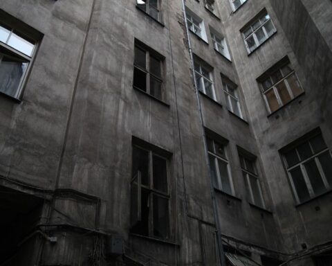 Dunkler Hinterhof, verwahrloste Immobilie, symbolisiert Kampf gegen Schrottimmobilien in NRW.