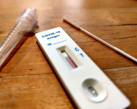 Ein Corona-Selbsttest auf einem Tisch, symbolisiert Betrug im Gesundheitswesen.