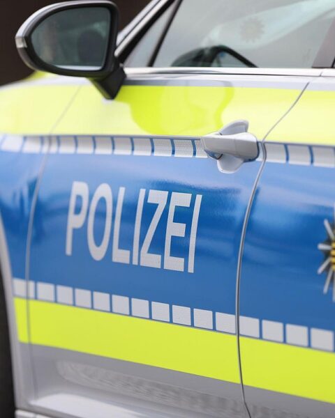 Polizeiauto an einer Unfallstelle mit verletzten Personen und abgesperrter Straße.