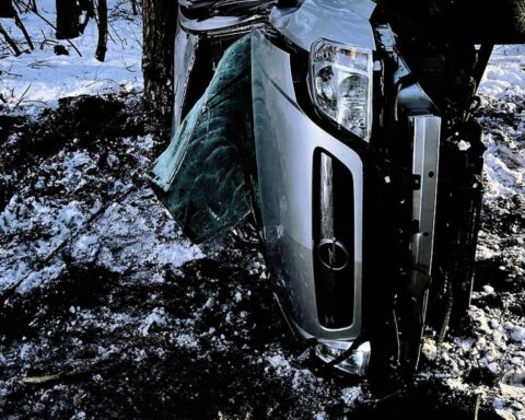 Verkehrsunfall mit überschlagenem Opel Meriva, Polizei und Rettungswagen im Hintergrund, drei Verletzte.