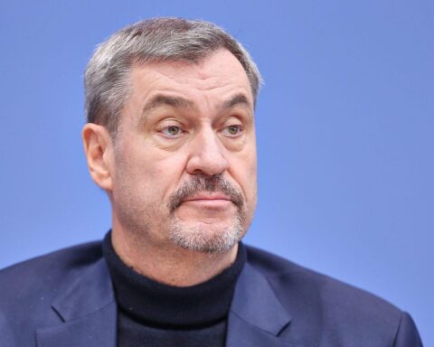 Markus Söder bei einer Ansprache, umgeben von Arbeitsmarktforschern und Diskutierenden.