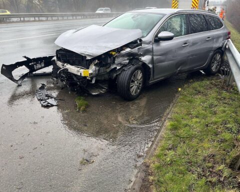 Unfallfahrzeug an Leitplanke, Regen, Polizei, Rettungswagen, beschädigte Straße, angepasste Fahrweise nötig.