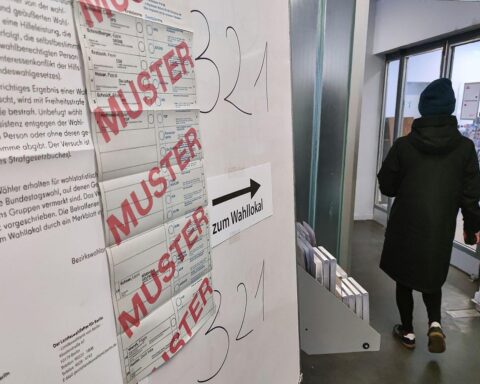 Wahllokal mit Wahlurnen und Wahlzetteln, symbolisiert Demokratie und aktuelle Wahlanfechtungen.