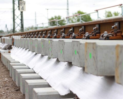 Baustelle der Deutschen Bahn mit Gleisen, Baustellenfahrzeugen und Hinweisen zu Fahrplanänderungen.