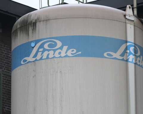 Linde-Logo vor einer Montageanlage, Symbol für Stellenabbau und wirtschaftliche Herausforderungen im Anlagenbau.