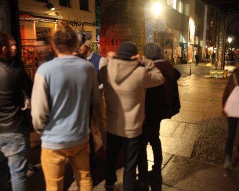 Junge Männer in urbaner Umgebung, nachdenklich, symbolisieren Herausforderungen und gesellschaftliche Erwartungen.