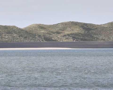 Hochwasserschutzanlagen an der Nordseeküste, Menschen arbeiten an Küstenschutzprojekten, präventive Maßnahmen.