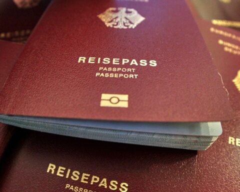 Ein Reisepass neben Sprachzertifikaten, Symbol für Einbürgerungsverfahren und Betrugsfälle.