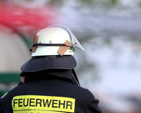 Feuerwehrmann im Einsatz, Rettungsmaßnahmen nach Chlorgasaustritt im Hallenbad mit Verletzten.