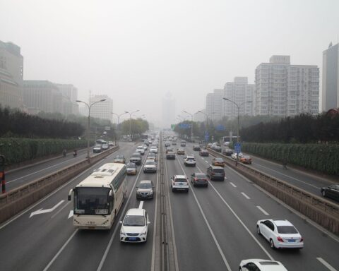 Straßenverkehr in Peking mit Autos und Menschen, symbolisiert Chinas wirtschaftliche Herausforderungen und Chancen.