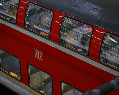 Regionalzug im Bahnhof, Diskussion über effizienteren Tarifverbund und Sicherheit im öffentlichen Verkehr.