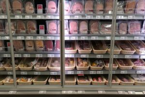 Supermarktregal mit verschiedenen Fleisch- und Wurstwaren, symbolisiert Fleischproduktion in Deutschland.