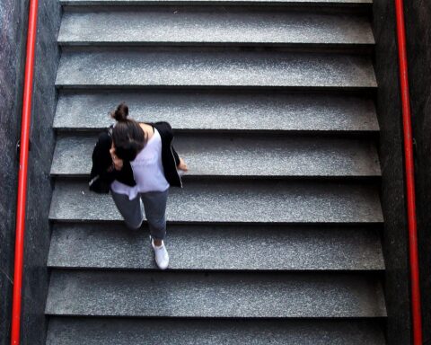 Frau nutzt Smartphone, während Telekom KI-Assistenten für Mobilfunknetz angekündigt.