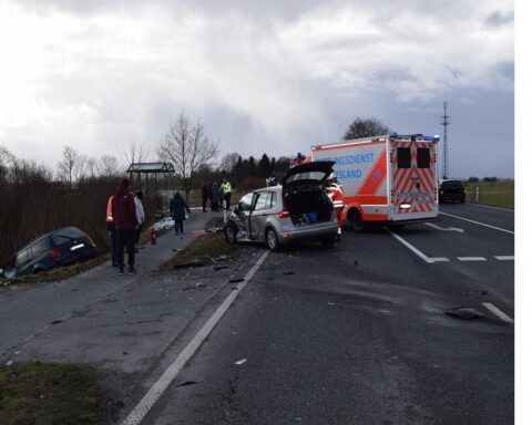 Verkehrsunfall auf Bundesstraße: beschädigte Autos, Polizei und Rettungswagen, verletztete Personen.