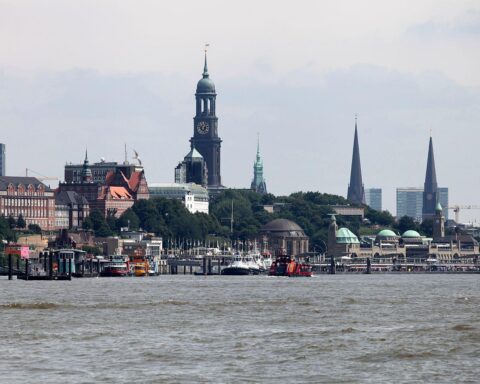 Eine moderne Brücke über die Norderelbe, umgeben von Hamburger Stadtansichten und Zügen.