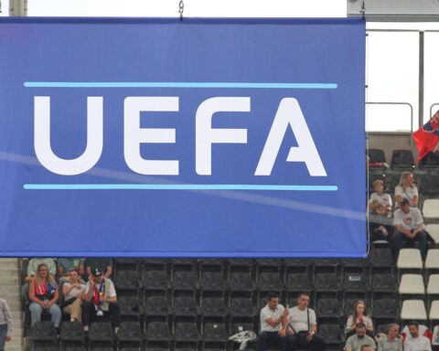 UEFA-Logo vor dramatischem Hintergrund symbolisiert Diskussion über Werte im Fußball und Boykottforderungen.