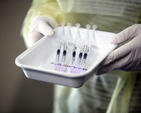 Auf gezogenem Impfstoff-Spritzen, Symbol für den neuen Kombi-Impfstoff gegen Influenza und Covid-19.