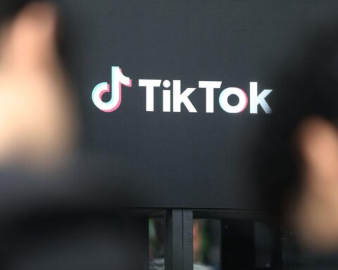 Tiktok-Logo vor Brüsseler Hintergrund, symbolisiert Prüfung des süchtig machenden Designs der App.