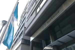 Ein besorgter Vermieter schaut auf ein Wohngebäude, symbolisiert den angespannten Wohnungsmarkt.
