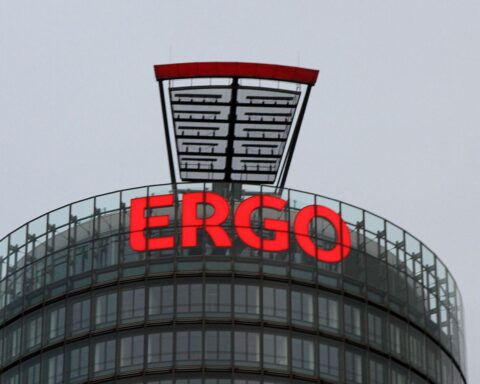 Ergo-Logo, Büroansicht, Mitarbeiter am Computer, symbolisiert Stellenabbau und Digitalisierung in der Versicherungsbranche.