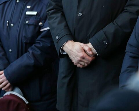 Schweigeminute für den verstorbenen Zugbegleiter, umgeben von betroffenen Menschen in Trauer.