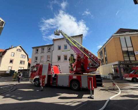 Drehleiter der Feuerwehr kontrolliert Dachbereich eines Hauses nach Ofen-Defekt in Weinheim.